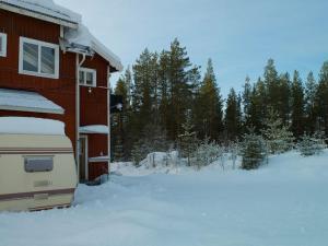 een camper geparkeerd naast een huis in de sneeuw bij Hedsjövägen 23 med 350m sandstrand 