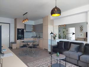 een woonkamer en een keuken met een bank en een tafel bij Mihaly Apartment in Sarandë