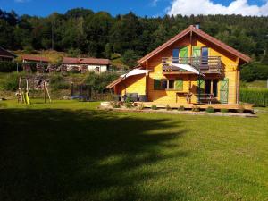 a house in a field with a large yard at Chalet des Brocards in Saint-Maurice-sur-Moselle