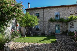 une maison en pierre avec une table et des chaises dans la cour dans l'établissement Cortis Antigas, à Gesturi