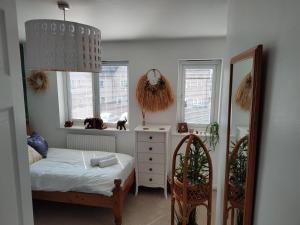- une chambre avec un lit, un miroir et des fenêtres dans l'établissement Mallard Court contractor/holiday home in Stamford, à Stamford