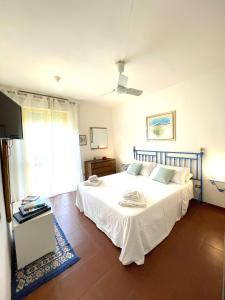 una camera da letto con un grande letto bianco e una finestra di Dimora dei pini a Leuca