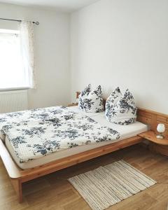 a bedroom with a bed with blue and white sheets and pillows at Ferienwohnung Berger in Reinhardtsdorf