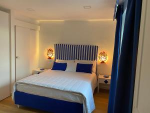 Appartamento vista mare Aria 'e mare tra Pompei e Sorrento في كاستيلاماري دي ستابيا: غرفة نوم مع سرير ذو أغطية زرقاء ومخدات زرقاء