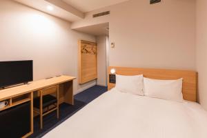 1 dormitorio con 1 cama y escritorio con TV en Sotetsu Fresa Inn Tokyo-Akasaka, en Tokio