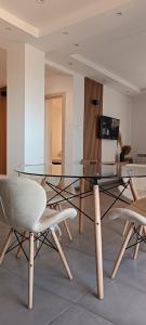un tavolo in vetro e sedie in camera di Logement Chic, résidence azaléa - Alger a Draria
