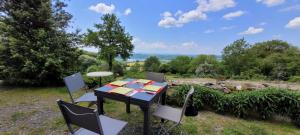 ein Tisch und Stühle mit Blick auf ein Feld in der Unterkunft Gîte à la tour de Peyrebrune in Alrance