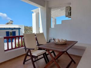 ein Holztisch und zwei Stühle auf einem Balkon in der Unterkunft Solid Residence in Triovasálos