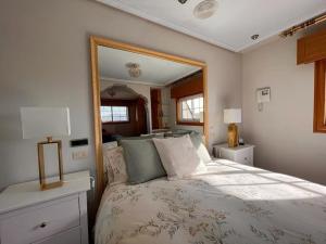 a bedroom with a bed with a large mirror at Villa overlooking Cies Islands in Vigo