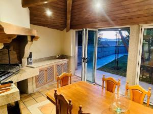 a kitchen with a wooden table and a large glass door at Villa overlooking Cies Islands in Vigo
