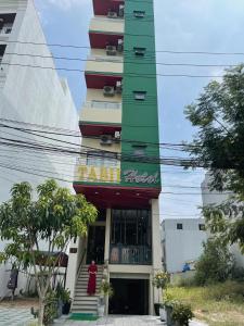 a tall building with a sign in front of it at Tabii hotel in Da Nang