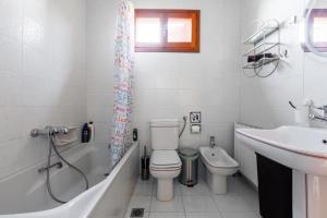 a bathroom with a toilet and a sink and a bath tub at Large Home near Potamos Beach in Epanomi