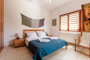 a bedroom with a bed with two towels on it at Large Home near Potamos Beach in Epanomi