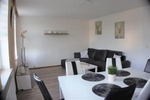 ein Wohnzimmer mit einem weißen Tisch und einem Sofa in der Unterkunft Ferienwohnung TrautesHeim - Parkplatz gratis in Ilmenau