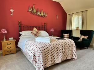 a bedroom with a bed and a red wall at Canaston Oaks in Narberth