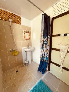 La salle de bains est pourvue d'une douche et d'un lavabo. dans l'établissement Tikehau cosy lodge, à Tikehau