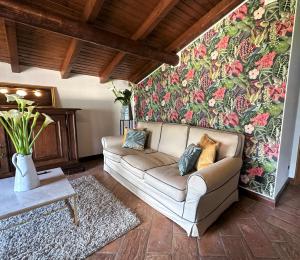 ein Wohnzimmer mit einem Sofa und einer Blumenwand in der Unterkunft L'antico Borgo in Cremia