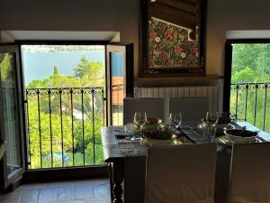 una mesa de comedor con copas de vino y un balcón en L'antico Borgo en Cremia