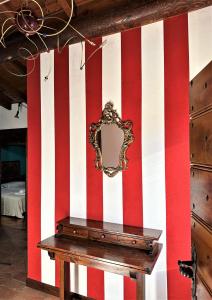 einem Spiegel an einer Wand mit roten und weißen Streifen in der Unterkunft L'antico Borgo in Cremia