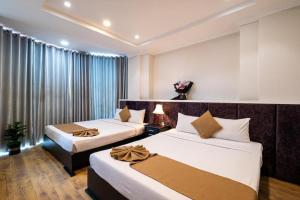 a hotel room with two beds and a window at Adina 3 Star Hotel in Danang