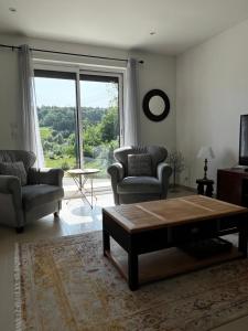 een woonkamer met een tafel en stoelen en een groot raam bij La côte du Muret in Fagnon