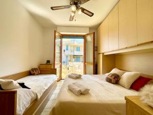 um quarto com 2 camas e uma ventoinha de tecto em 2 locali a 600 mt dal Mare - Free Parking em Ceriale