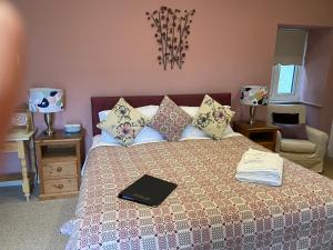 Un dormitorio con una cama con un libro. en Canaston Oaks, en Narberth