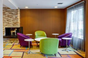 een kamer met een tafel en stoelen en een open haard bij Fairfield Inn & Suites by Marriott Edmond in Edmond