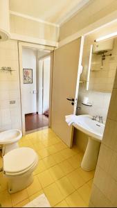 La salle de bains est pourvue de toilettes blanches et d'un lavabo. dans l'établissement Dimora dei pini, à Leuca