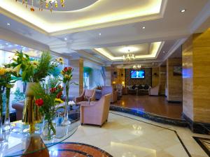 a lobby of a hotel with chairs and flowers at Boudl Kuwait Al Fahahil in Kuwait