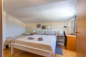 a bedroom with a bed and a desk at Apartments Valeria, Mali Lošinj in Mali Lošinj