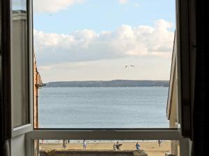 a view of a beach from a window at Sea Blue Cottage in Scarborough