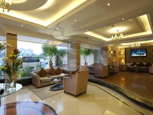 a lobby with couches and a tv in a building at Boudl Kuwait Al Fahahil in Kuwait