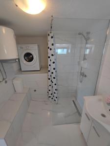 y baño con ducha y lavadora. en Apartment Filip, en Trogir