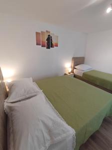 a bedroom with two beds with green and white sheets at Apartment Filip in Trogir