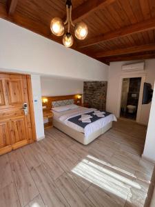 - une chambre avec un grand lit et un plafond en bois dans l'établissement Yelken Hotel Akyaka, à Akyaka