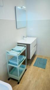 uma casa de banho com um lavatório e uma prateleira com toalhas em Ambrogio Mare em Varazze