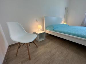 um quarto com uma cadeira branca e uma cama em Ambrogio Mare em Varazze