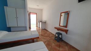 Habitación con cama, espejo y barra. en Blue Sand, en Kalymnos