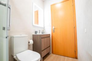 een badkamer met een toilet en een houten deur bij Villa7pax baby friendly Near Dino Park&Beaches in São Bartolomeu