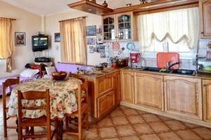 a kitchen with wooden cabinets and a table and a dining room at Ikaria Studios in Manganítis
