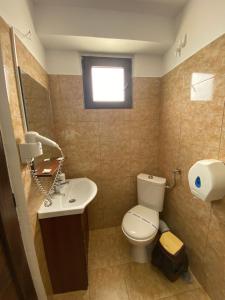 a bathroom with a toilet and a sink and a window at Kherim in Vama Veche