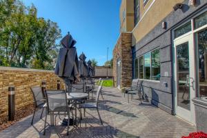 a patio with chairs and umbrellas next to a building at Fairfield Inn & Suites by Marriott Appleton in Appleton