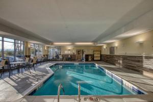 una piscina en una habitación de hotel con mesa y sillas en Fairfield Inn & Suites by Marriott Appleton, en Appleton