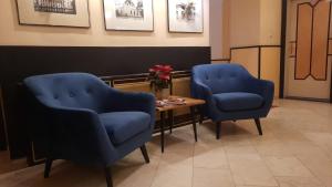 zwei blaue Stühle und ein Tisch im Wartezimmer in der Unterkunft Hotel Klimt in Wien