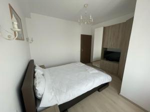 a small bedroom with a bed and a television at East View by DAT Apartments in Cluj-Napoca