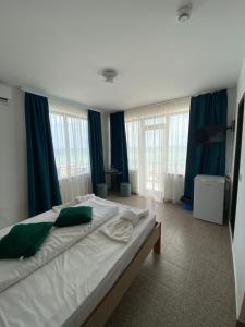 a bedroom with a large bed with blue curtains at Kherim in Vama Veche