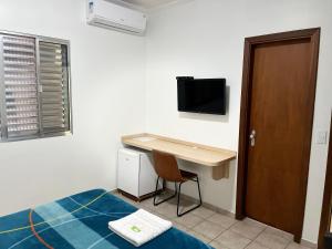 a bedroom with a desk and a bed and a desk at Hotel Taquaral in Campinas