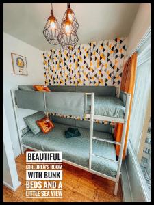 a room with two bunk beds and a little sea view at CASA MARE hartje Oostende met gratis parking in Ostend