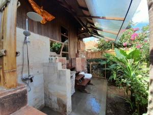 ein Bad mit Dusche in einem Gebäude in der Unterkunft Rasasvada cottages in Uluwatu